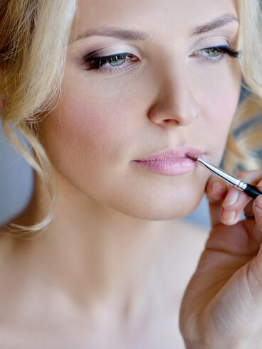 Wedding makeup artist making a make up for bride