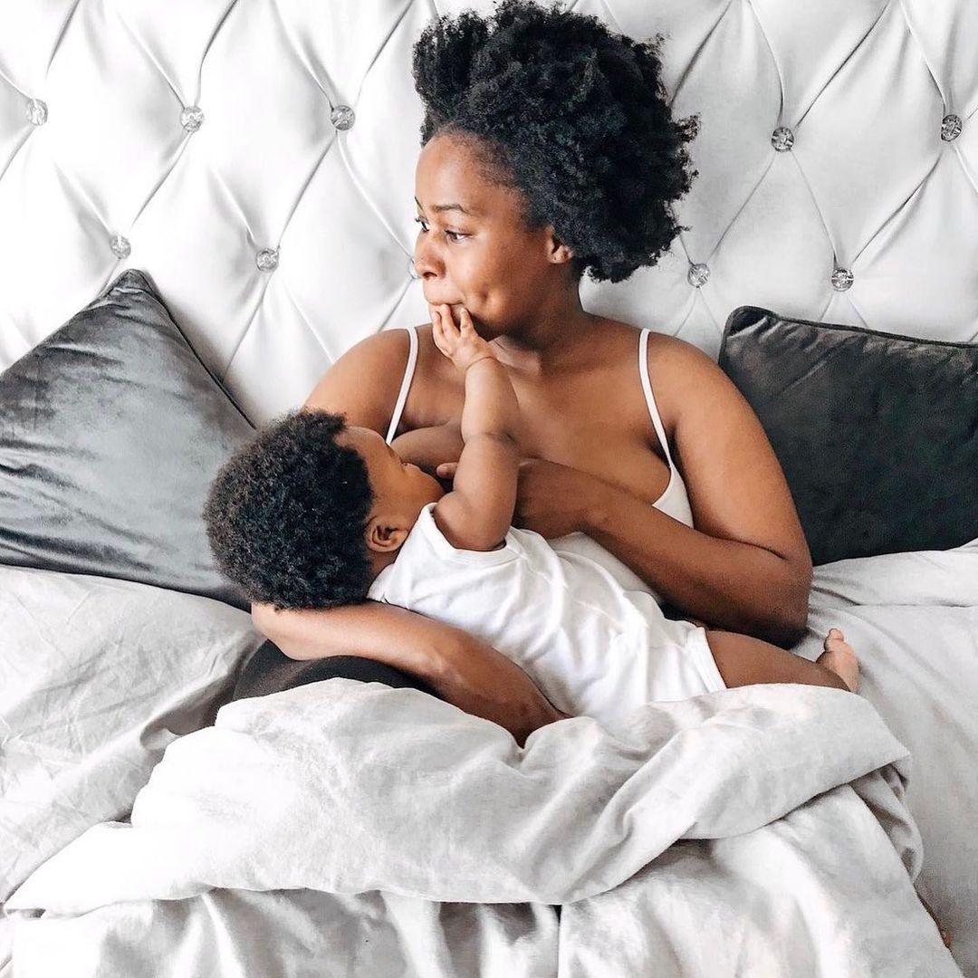 Mum breastfeeding baby on bed