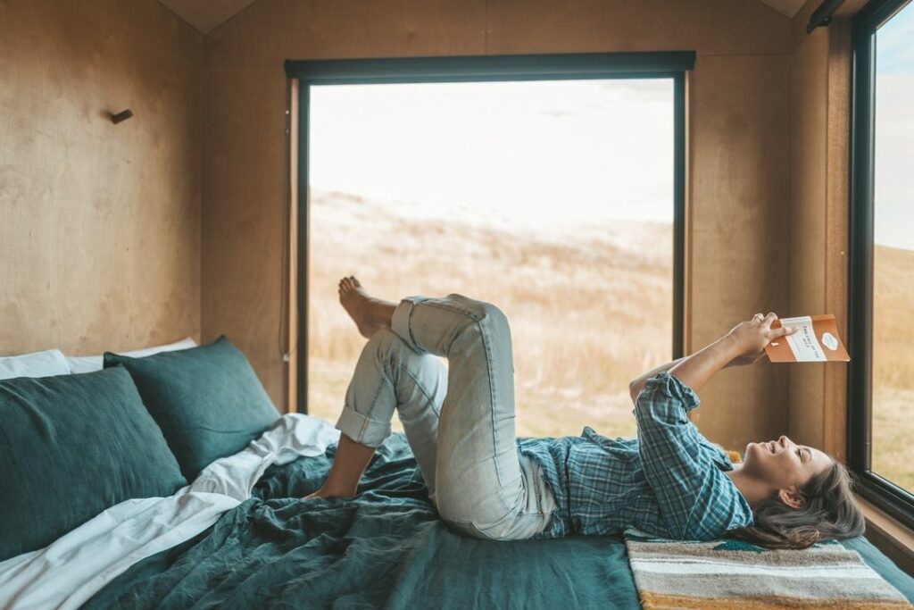 woman laying on bed reading