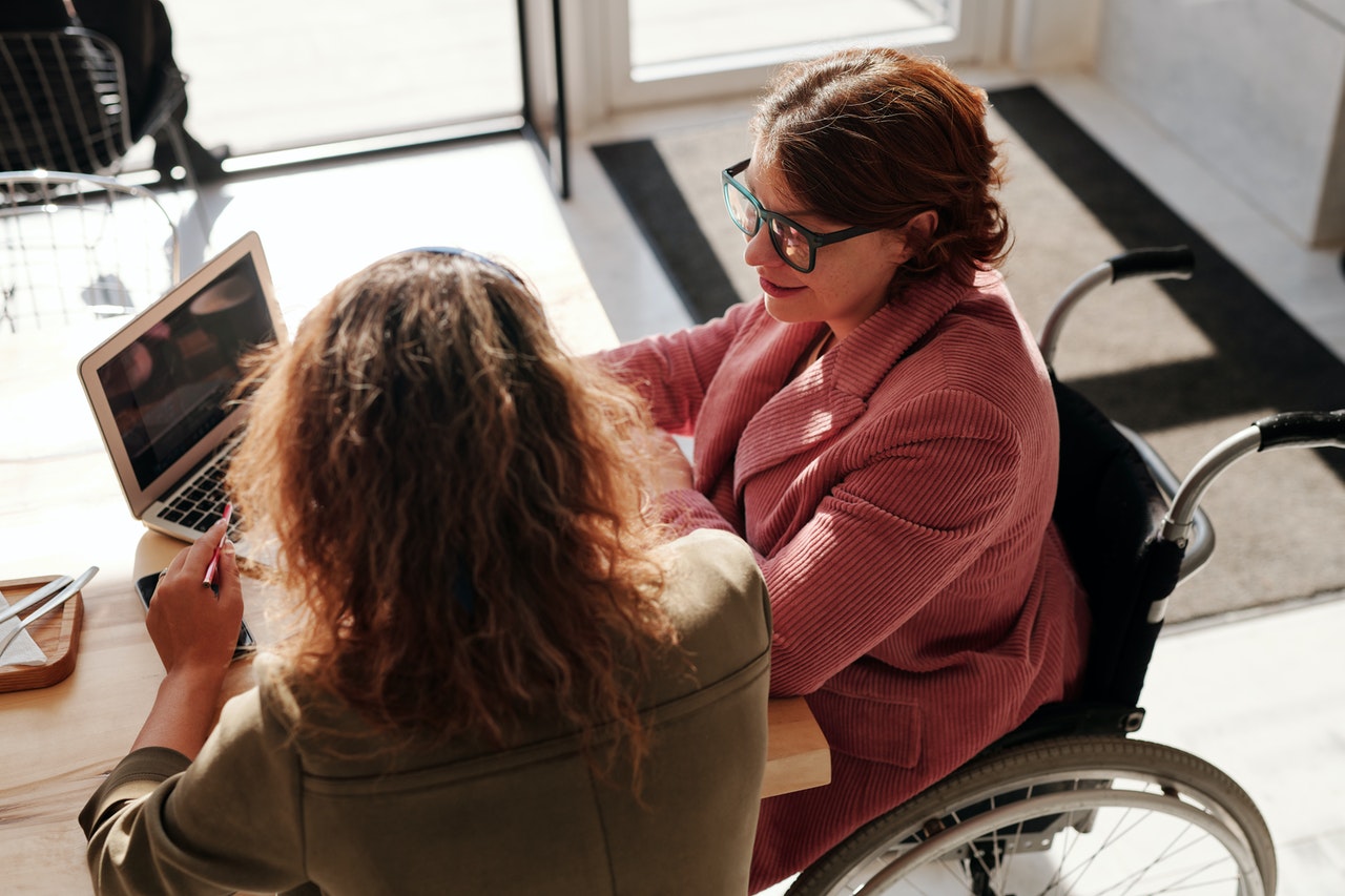 woman-in-red-sweater-wearing-black-framed-eyeglasses-sitting-on-wheelchair