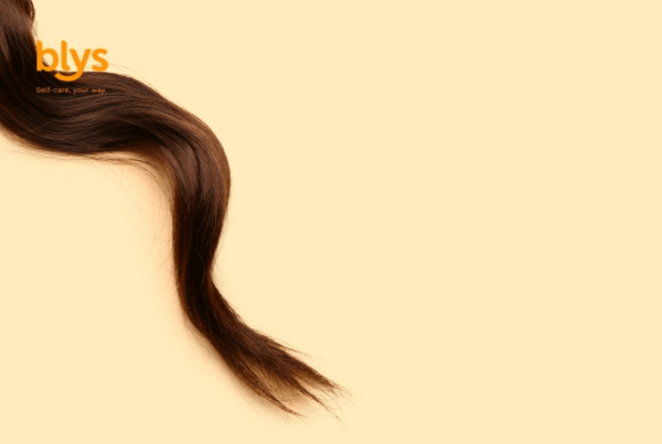 Minimalist Blys wellness graphic: flowing dark brown hair with medium porosity curves across a warm cream background beneath the orange “blys” logo, creating a calm, elegant mood.