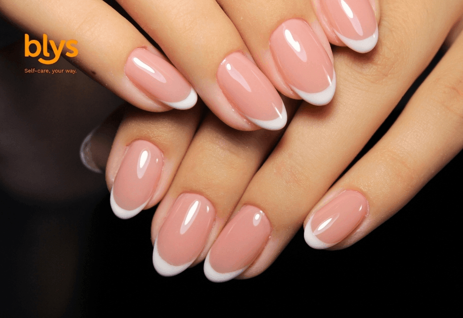 Close-up of manicured hands with glossy pink-and-white acrylic nails layered against a black background, conveying elegance and polish.