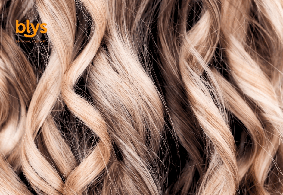 Close-up of balayage curls with soft waves and textured strands, creating a luxurious, warm, salon-inspired beauty mood.