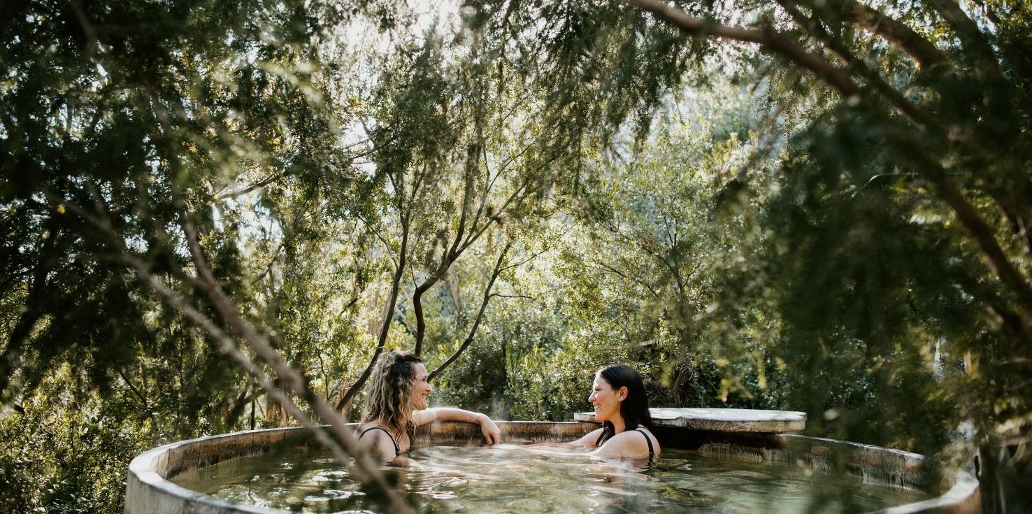 Two women talking in a spa in nature