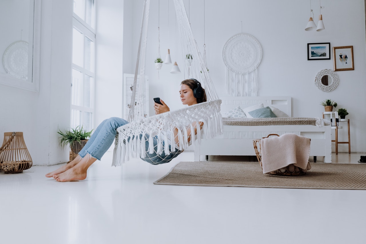 woman-in-white-and-blue-long-sleeve-shirt-and-blue-denim-jeans-lying-on-white-bed