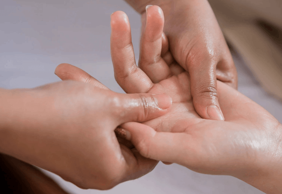 A close-up of two hands gently massaging another person’s hand and fingers for carpal tunnel and wrist pain, conveying a tender, caring moment of comfort and connection.
